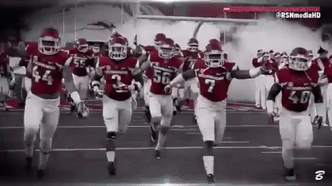 Football Players Running on Field Black and White