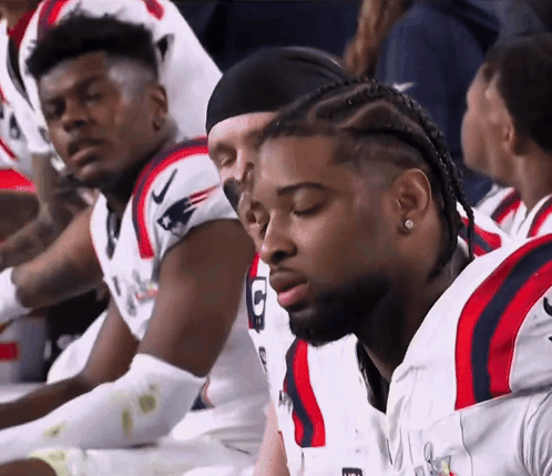 Football Players Sitting in Row With Letter G Jersey