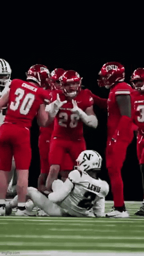 Football Players Standing Around Injured Player on Field