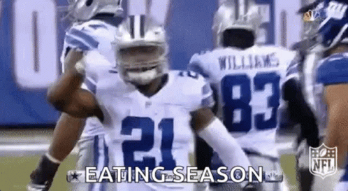 Football Players Standing on Field Eating Season