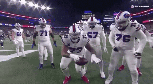 Football Players Standing on Field Holding Ball