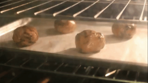 Four Cookies Baking In Oven On Wax Paper GIF