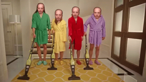 Four Men In Bathrobes Are Holding Vacuum Cleaners In A Hallway GIF