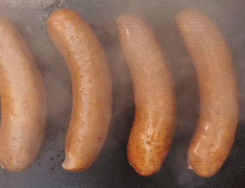 Four Sausages Are Being Cooked On A Grill And Smoke Is Coming Out Of Them GIF