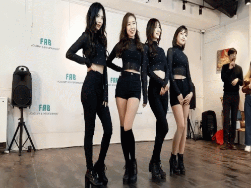 Four Women Standing in Front of Fab Sign