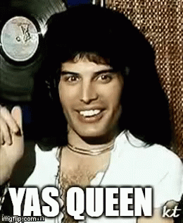 Freddie Mercury Is Smiling And Giving A Thumbs Up In Front Of A Record . GIF