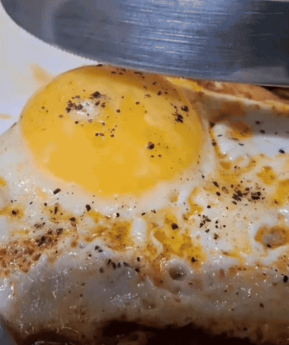 Fried Egg Being Cut With Knife