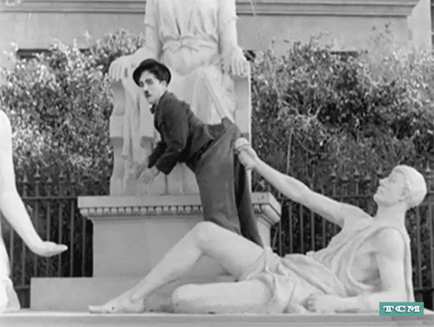 Funny Vintage Charlie Chaplin Hanging On Statue GIF
