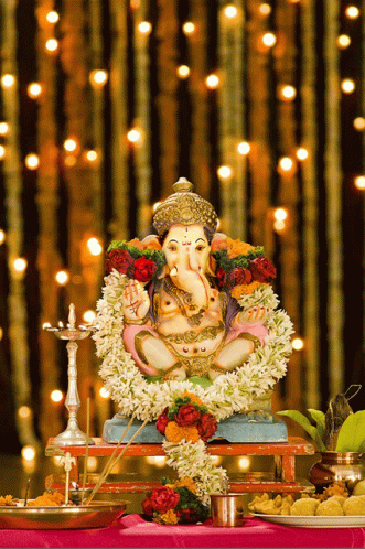 Ganesha Statue on Table With Flowers