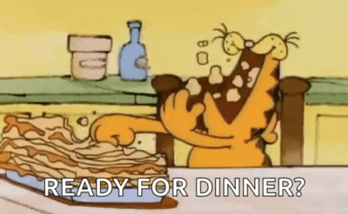 Garfield Is Sitting At A Table Eating A Lasagna . GIF