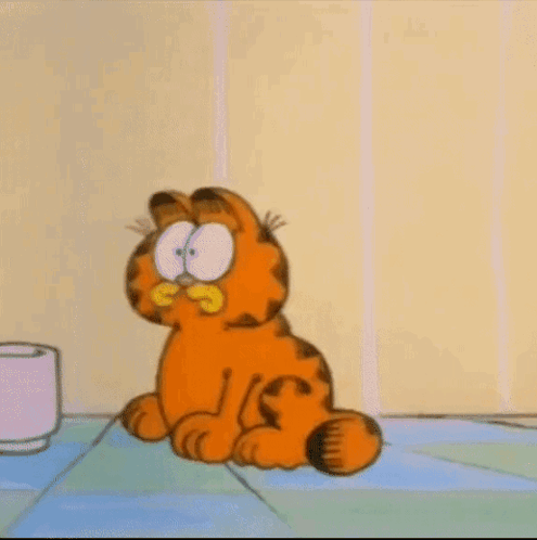 garfield the cat is sitting on a tiled floor next to a cup of coffee .