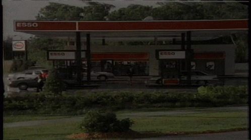 Gas Station With Cars And Esso Sign GIF