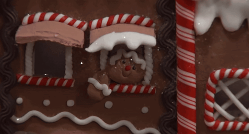 Gingerbread House With Candy Canes And Man GIF