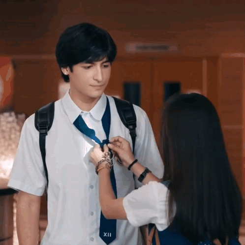 Girl Adjusting Boy's Tie With Number XII