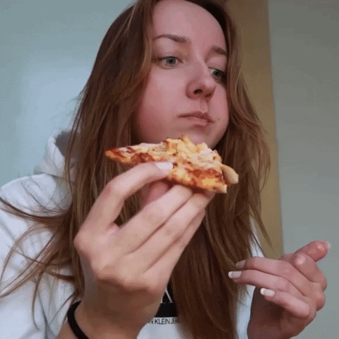 Girl Chewing Pizza With A Blank Stare GIF