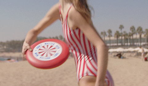 Girl Enjoying Frisbee At Beach GIF