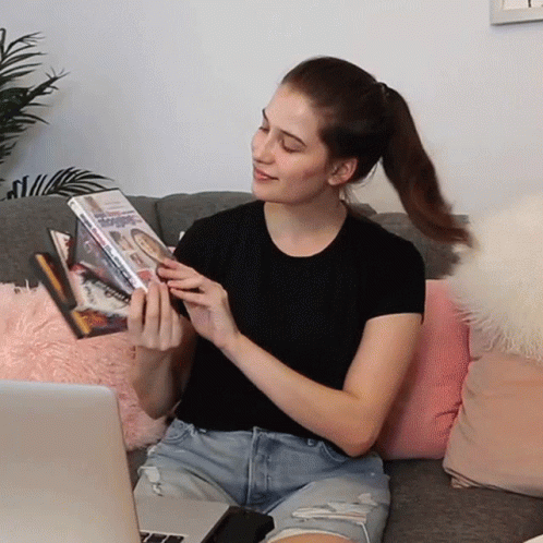 Girl Flexing Her Dvd Collection GIF
