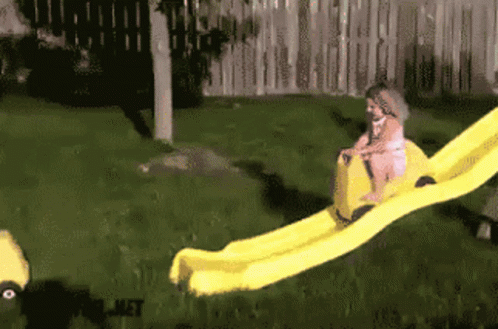 Girl Going Down Yellow Slide With Word Met Visible