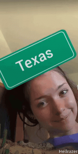 Girl Holding Green Sign Saying Texas on Head