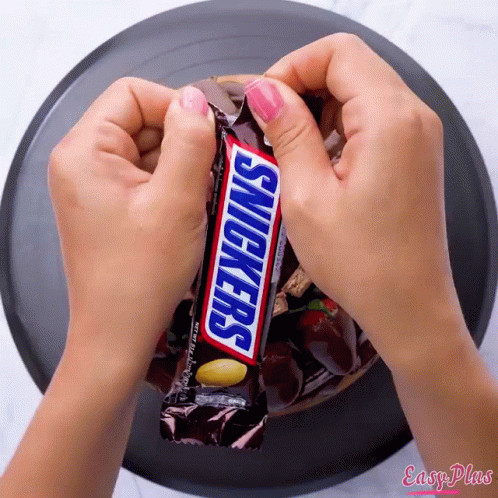 Girl Holding Snickers Bar Another Says Have a Snickers