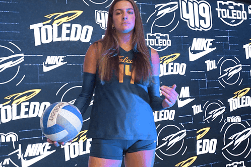 Girl Holding Volleyball in Front of Toledo Wall