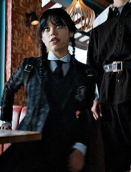Girl in Black Jacket and Tie Sitting at Table
