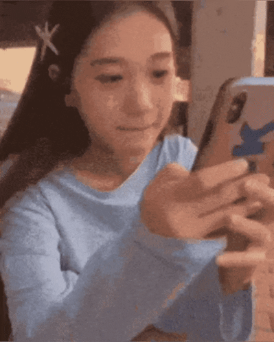 Girl In Blue Shirt Looking At Cell Phone GIF