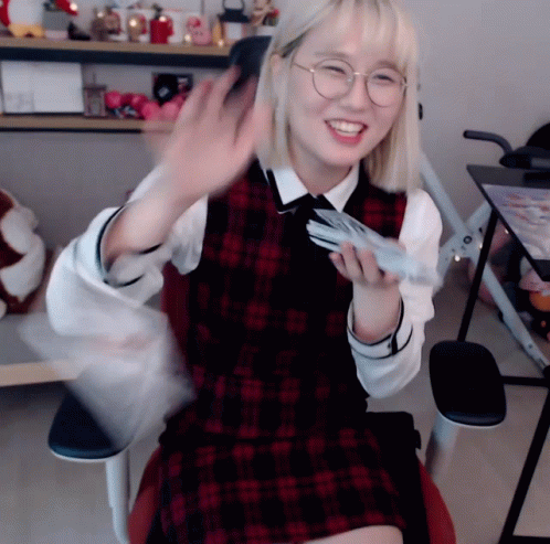 Girl in Glasses and Plaid Vest Sitting