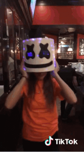 Girl in Orange Shirt with Lit Marshmello Hat