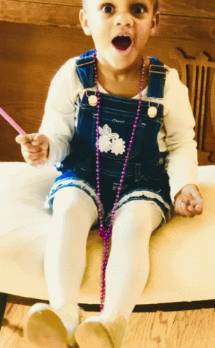 Girl in Overalls Sitting on Chair
