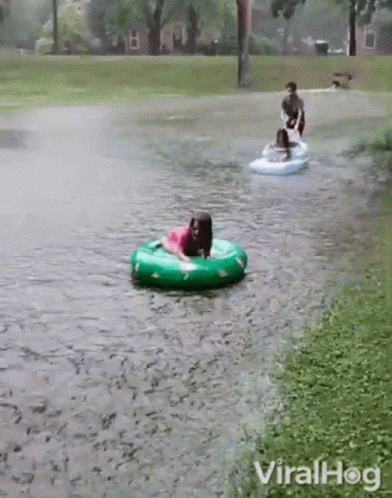 Girl In Pink Dress Riding Green Inner Tube GIF