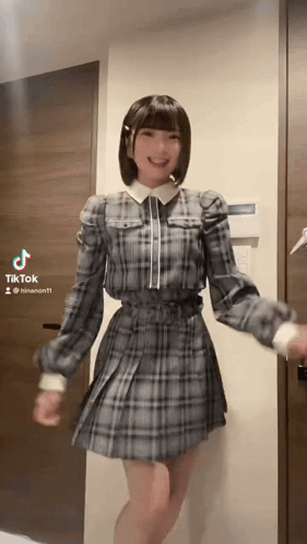 Girl in Plaid Dress Dancing by Door with TikTok
