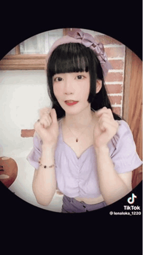 Girl in Purple Top With Pink Headband Making Heart Shape