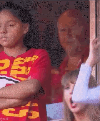 Girl in Red Shirt Number 25 Next to Woman in Blue Shirt