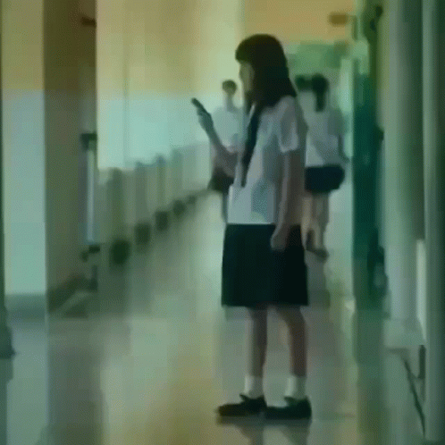 Girl in School Uniform Looking at Cell Phone