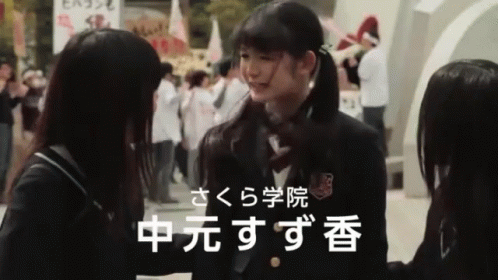 Girl in School Uniform Talking to Girl With Chinese Writing
