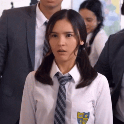 Girl In School Uniform With Pigtails And Tie Standing In Crowd GIF