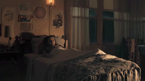 Girl in Striped Shirt Sitting on Bed