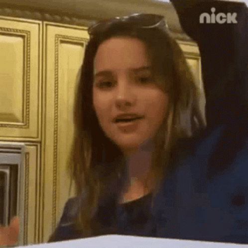 Girl in Sunglasses With Arm Up in Kitchen