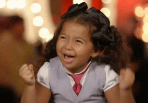 Girl In Vest And Tie Cheering With Fist Up GIF