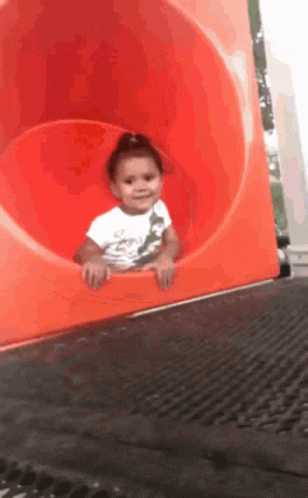 Girl in White Shirt Going Down Orange Slide