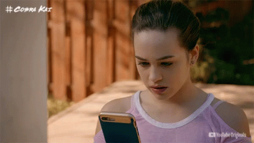 Girl Looking at Cell Phone with Cobra Kai Logo