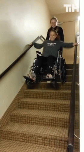 Girl Pushing Another Girl In Wheelchair Down Stairs GIF