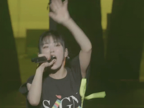 Girl Singing Into Microphone In SGN Shirt GIF