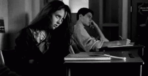 Girl Sitting at Desk Next to Boy