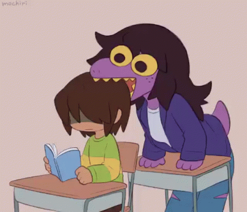 Girl Sitting at Desk Reading Book Next to Purple Hair Girl