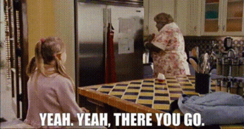 Girl Sitting At Refrigerator Table With Woman Behind GIF