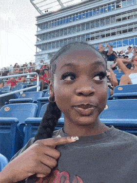 Girl Sitting in Stadium Pointing at Flamingo
