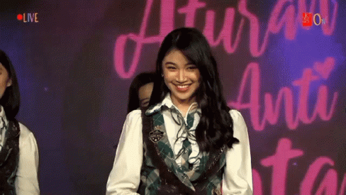 Girl Smiling at Sign Saying Live