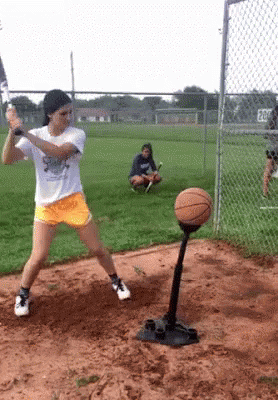 Girl Swinging Bat at Basketball on Tee